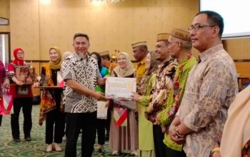 Penjabat Sekdaprov Gorontalo Budiyanto Sidiki saat menyerahkan hadiah kepada pemenang lomba desa lokus tengkes berbasis Germas, usai membuka kegiatan Pertemuan Implementasi Kebijakan Germas yang bertempat di Grand Q Hotel Kota Gorontalo, Jum’at (11/08/2023). Foto – Winda