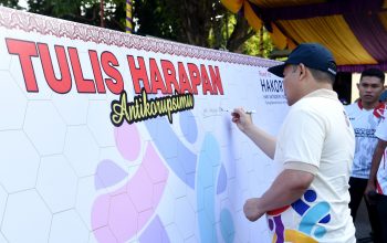 Penjagub Ismail Pakaya menuliskan harapan antikorupsi pada pencanangan kegiatan Hakordia tahun 2023 tingkat Provinsi Gorontalo di Lapangan Taruna Remaja, Kota Gorontalo, Minggu (5/11/2023). (Foto : Haris)